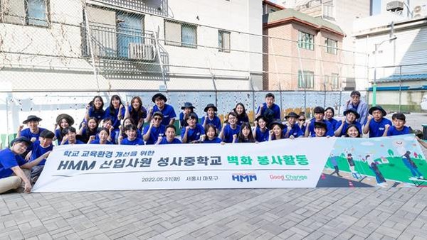 지난달 31일 마포구 성사중학교에서 진행된 ‘교육환경 개선을 위한 HMM 신입사원 벽화 그리기 봉사활동’에서 신입사원들이 완성된 벽화 앞에서 기념 촬영을 하고 있다. (사진=HMM)