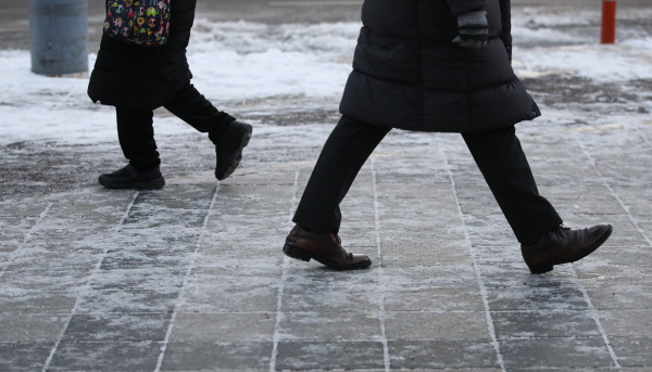 20일 낮부터 북극 한기가 내려오면서 영하권 맹추위가 전국에 몰아치겠다. 사진은 서울 광화문 사거리에서 시민들이 얼어붙은 길바닥위를 조심스레 걷고 있는 모습. /뉴시스