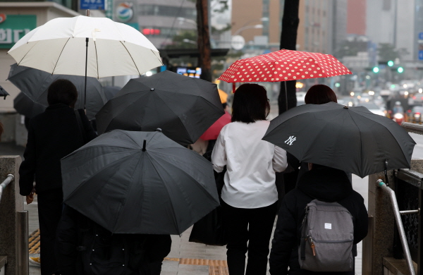 20일 기온이 전날보다 최대 10도나 가파르게 떨어져 쌀쌀하겠다. 사진은 서울 충무로역 인근에서 우산을 쓴 직장인들이 출근길 걸음을 재촉하고 있는 모습. /뉴시스