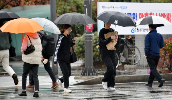 23일 한낮 최고기온이 23도까지 오르면 포근하겠다.. 사진은 광주 동구청 주변 교차로에서 시민들이 우산을 쓴 채 횡단보도를 걷고 있는 모습. /뉴시스