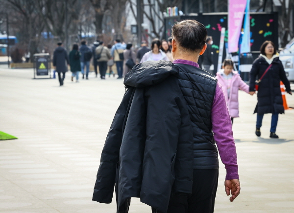 27일  내륙을 중심으로 낮 기온이 19도까지 올라 포근하겠다. 사진은 서울시 종로구 광화문 광장에 한 시민이 포근한 봄날씨에 외투를 들고 지나가고 있는 모습. /뉴시스