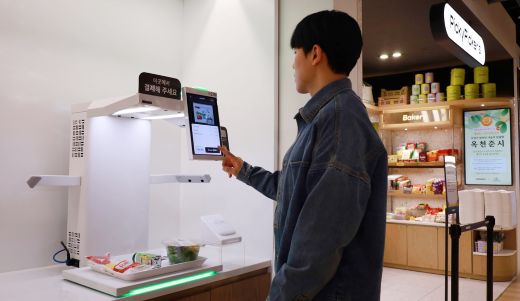 구내식당 이용자가 'AI 스캐너'를 이용해 간편식을 결제하고 있다.